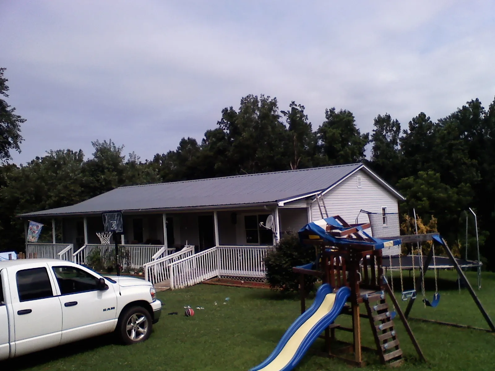 Dark metal roof on a country home with a full length front porch in Stratford