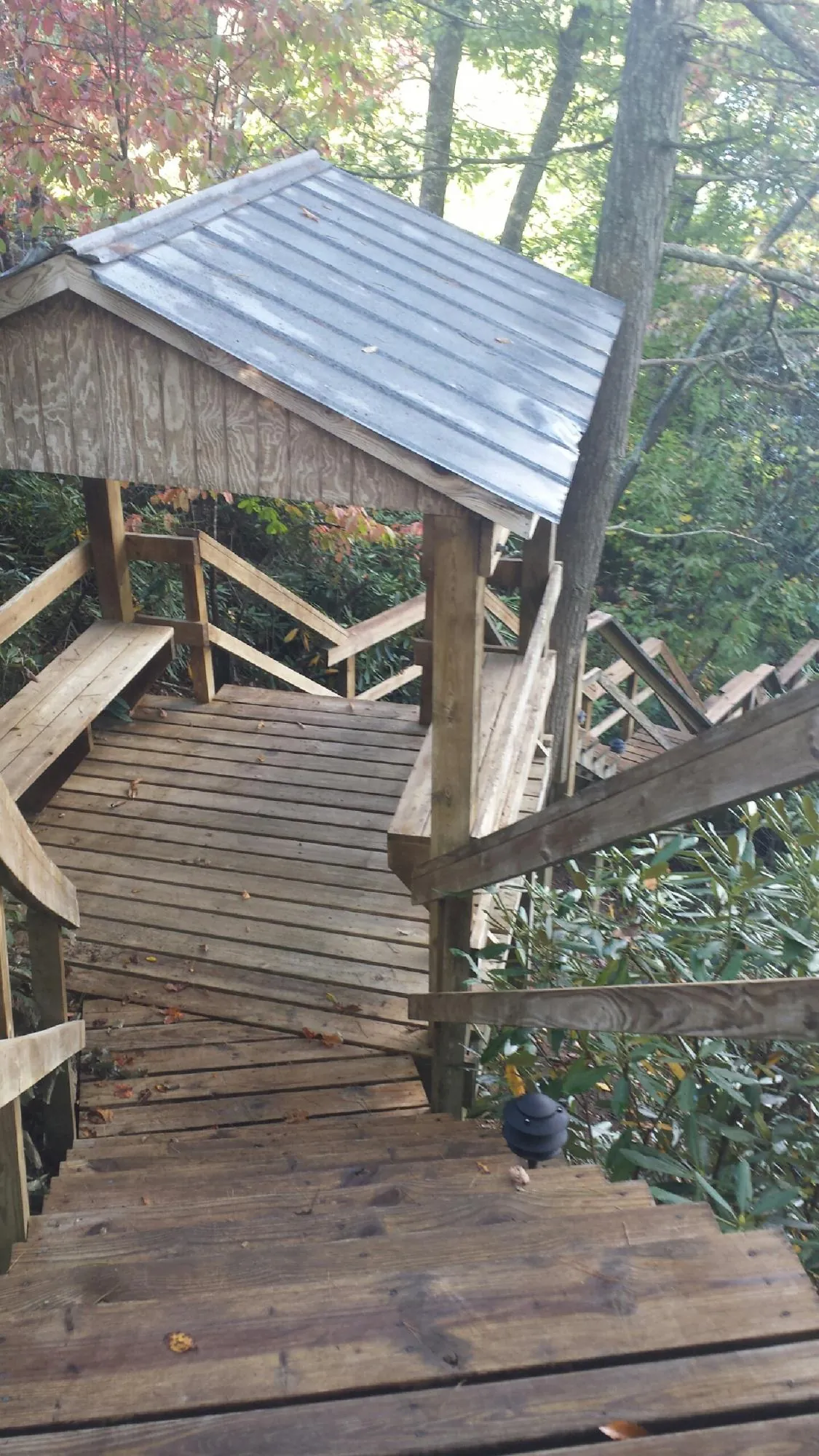 Metal roofed shelter over wooden steps on a wooded walkway — Skylight Repair & Installation work by our crew in Stratford